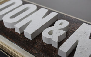 plywood sign with textured panel and raised letters