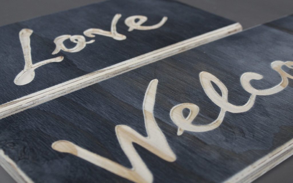 Love - black stained plywood sign with shallow carved letters