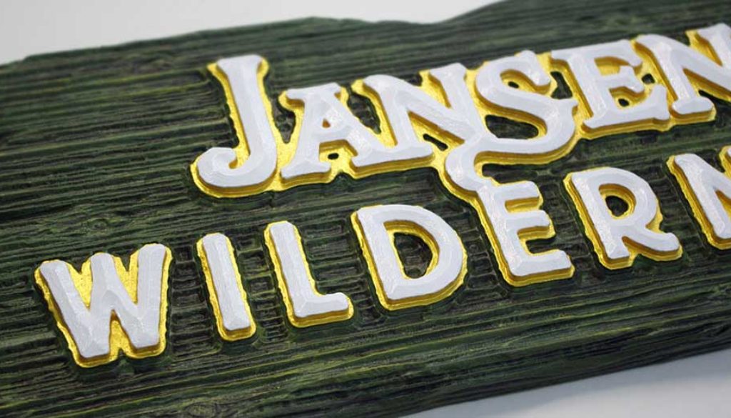 carved sign with wood grain and prismatic letters