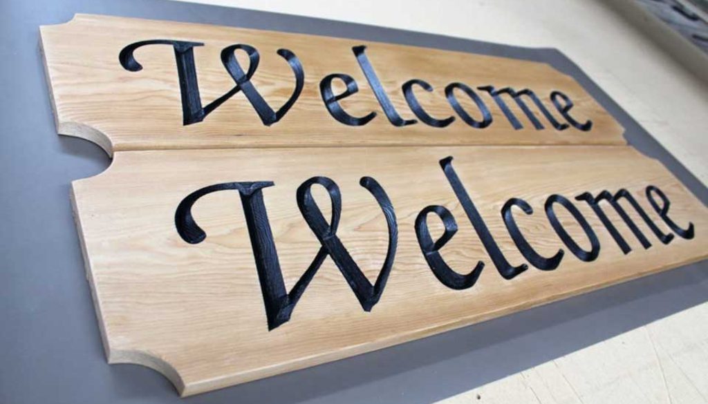 Carved wooden signs that say "Welcome"