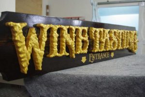 wood sign with raised gold letters