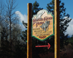 Wooden sign between two log posts "Red-Tail Canyon Farm"