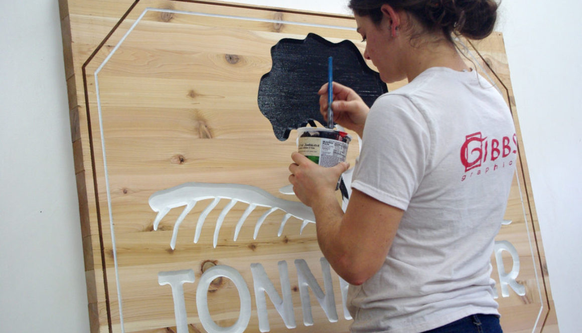 Large wooden sign with carved down letters