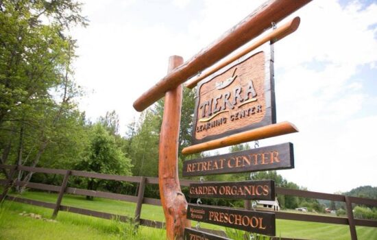 Tierra Learning Center wood sign with log posts.