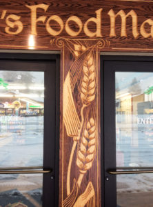decorative wood carving between two business doors