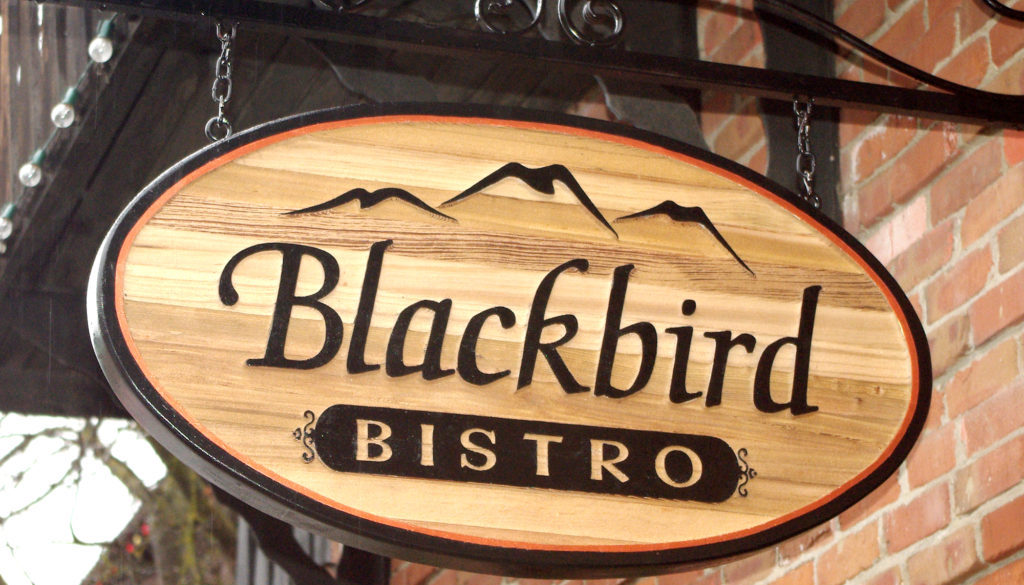 Wooden sign with black words Blackbird Bistro.