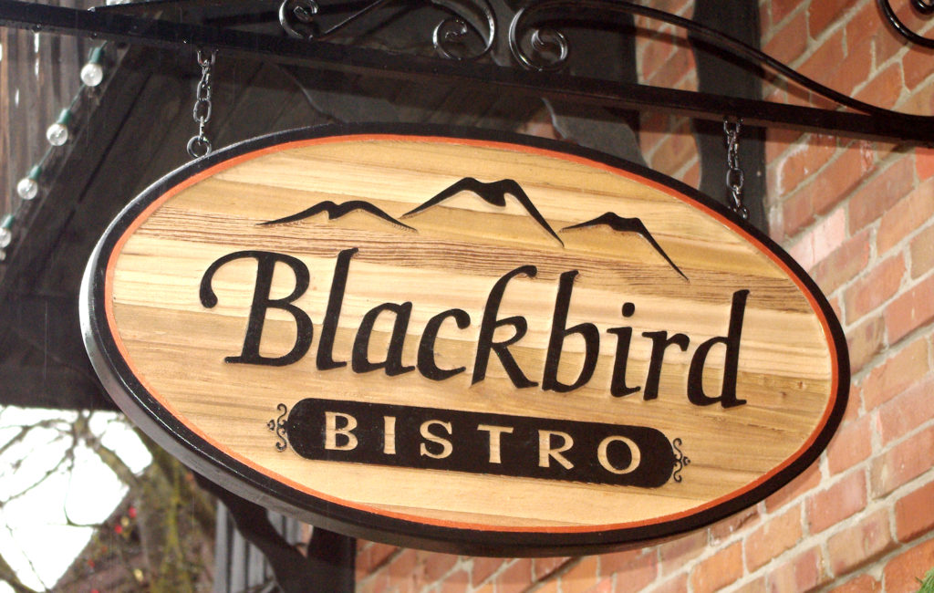 Wooden sign with black words Blackbird Bistro.