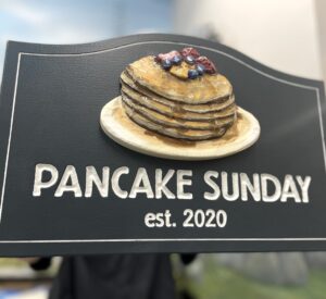 sign with a stack of 3D carved pancakes and sculpted berries