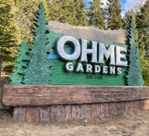 large sign with trees and wood base