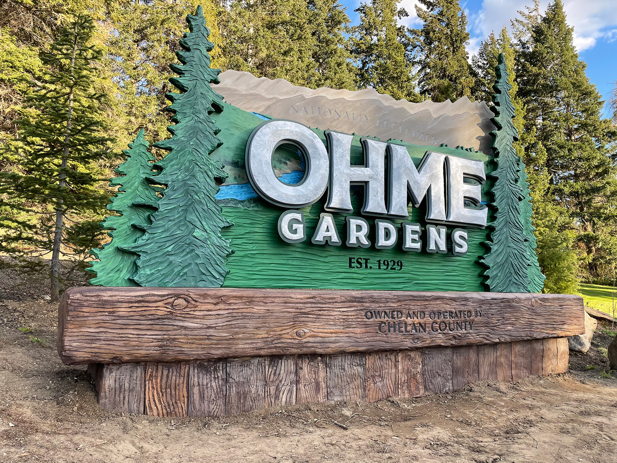 large sign with trees and wood base
